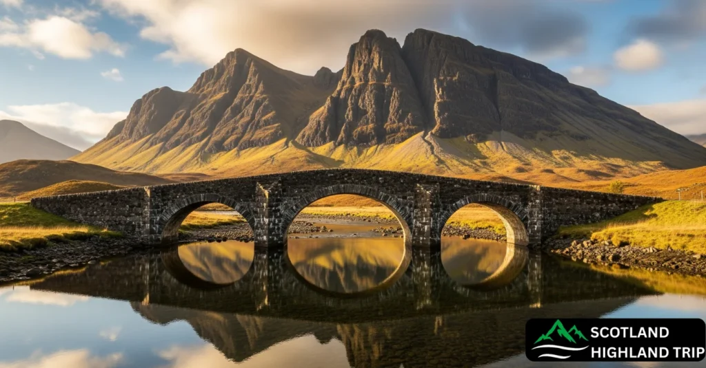 Historic triple-arched Sligachan Bridge with Cuillin mountains in the background under golden light